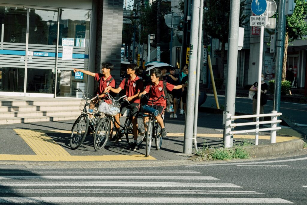 Three people on bicycles pointing at something.