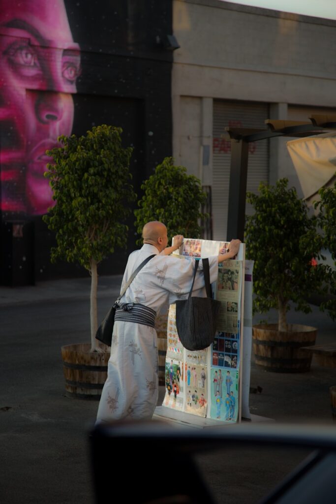 person standing in front of poster near building during daytime