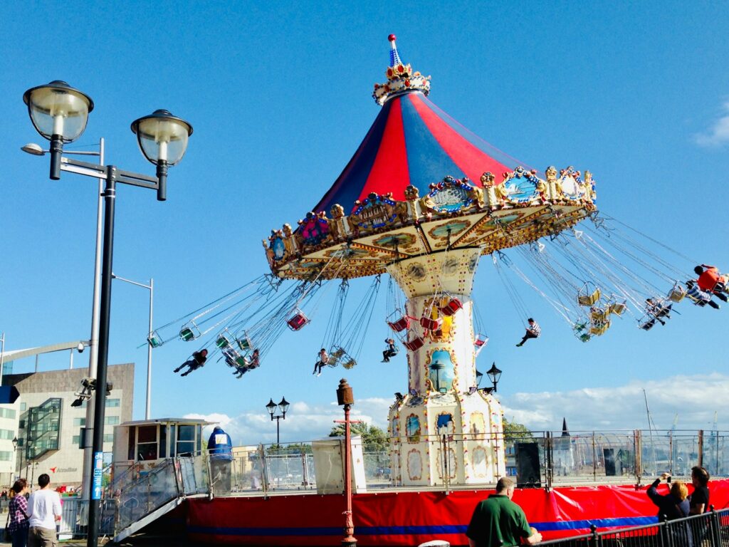 people standing on red and blue carousel during daytime