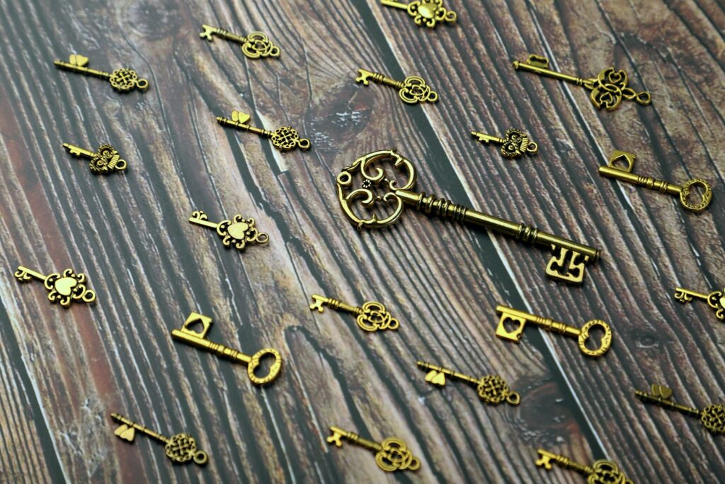 silver and gold skeleton key on wooden surface