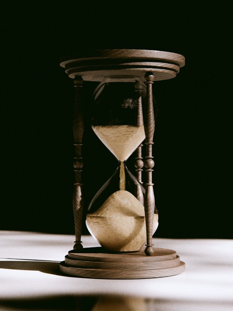 An antique hourglass with sand flowing